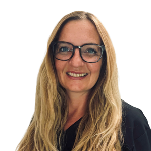Portrait Christina Bosse. Frau mit blonden Locken und Brille, trägt graue Arbeitskleidung, lächelt immer freundlich und ist nett am Telefon.