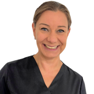 Portrait Dr. med. dent. Silke Pietzka. Lächelnde Frau in blauer medizinischer Kleidung vor hellem Hintergrund.
